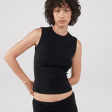 Person wearing a black sleeveless top and black skirt.