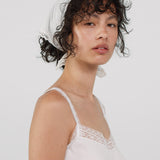 Woman wearing a white lace scarf with a plain background