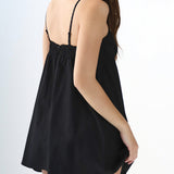 Black slip dress worn by a person on a white background