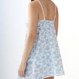 Woman wearing a light blue floral dress on a white background