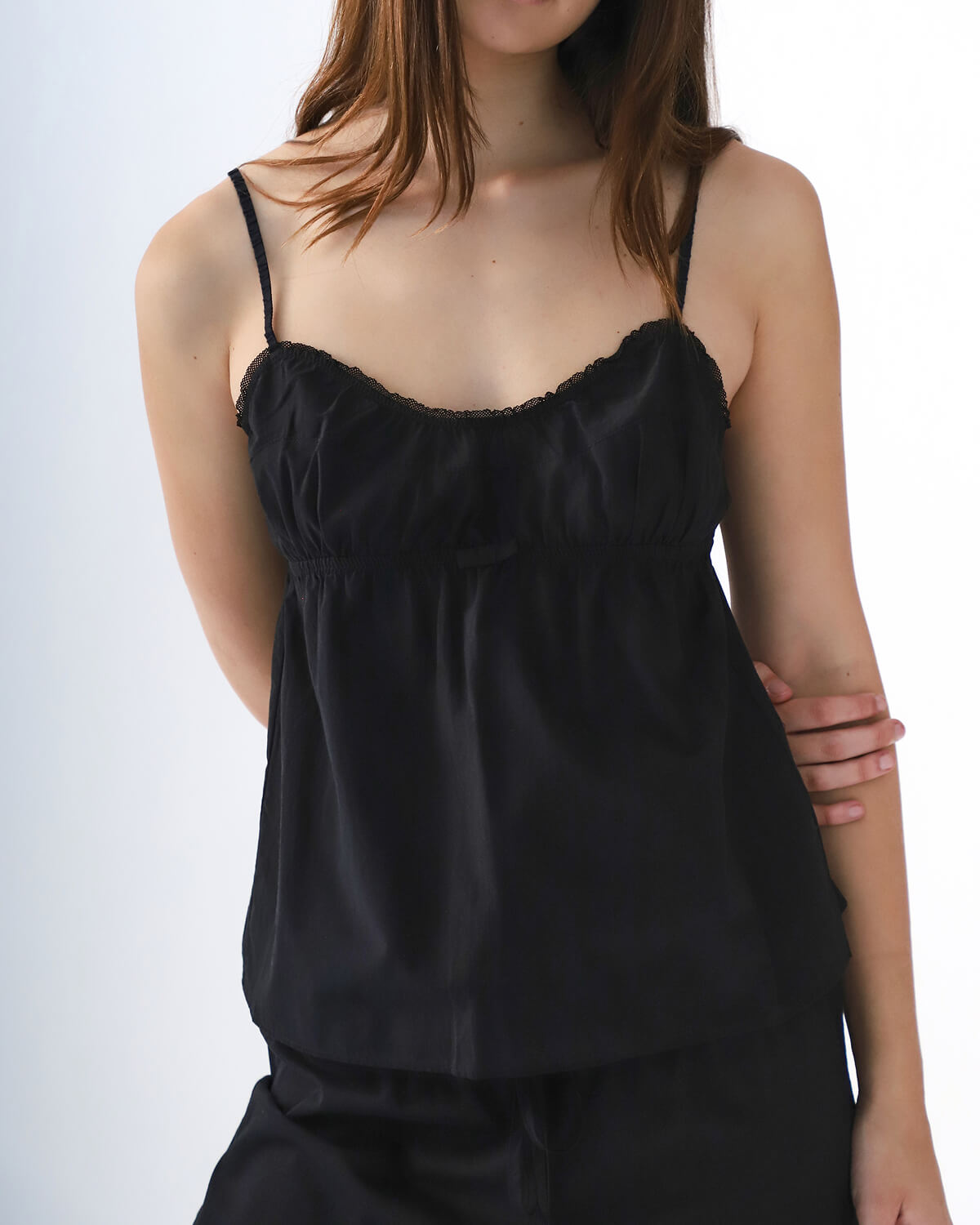 Black camisole worn by a person on a white background