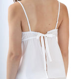 White strappy top worn by a person on a white background