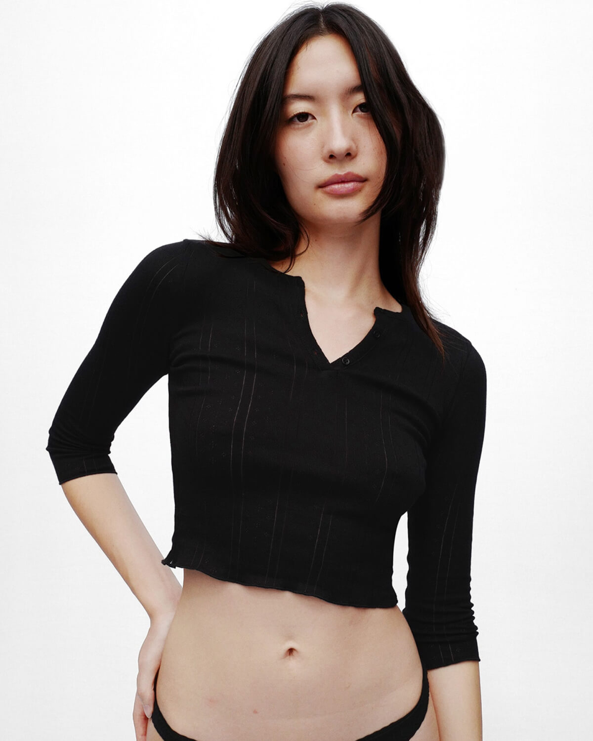 Woman wearing a black long-sleeve top against a white background