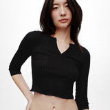 Woman wearing a black long-sleeve top against a white background