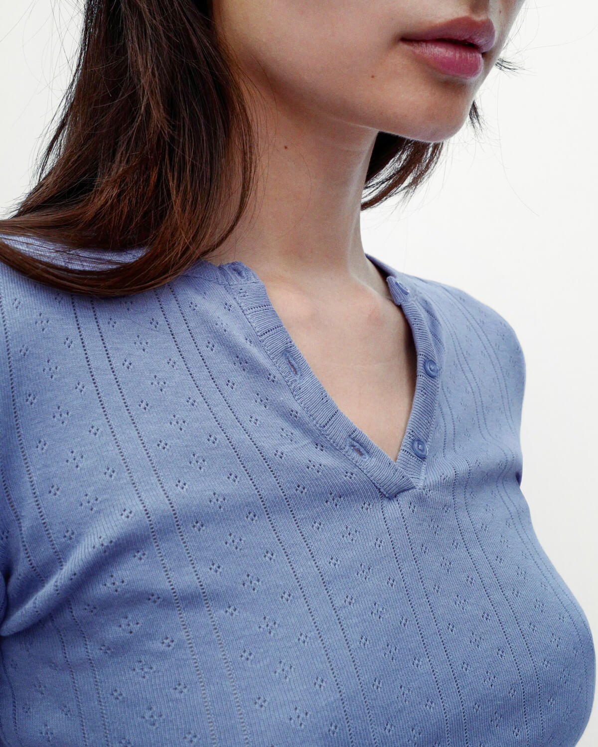 Close-up of a person wearing a blue patterned top on a white background