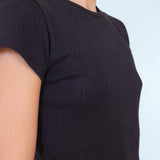 Black t-shirt worn by a person on a light blue background