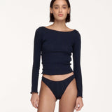 A model wearing a dark navy blue long-sleeve top.