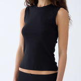 Woman wearing a black sleeveless top against a white background