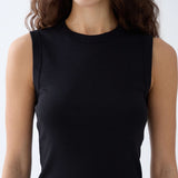 Black sleeveless top worn by a person on a white background