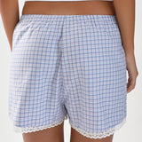 Blue checkered shorts with lace trim worn by a person on a white background