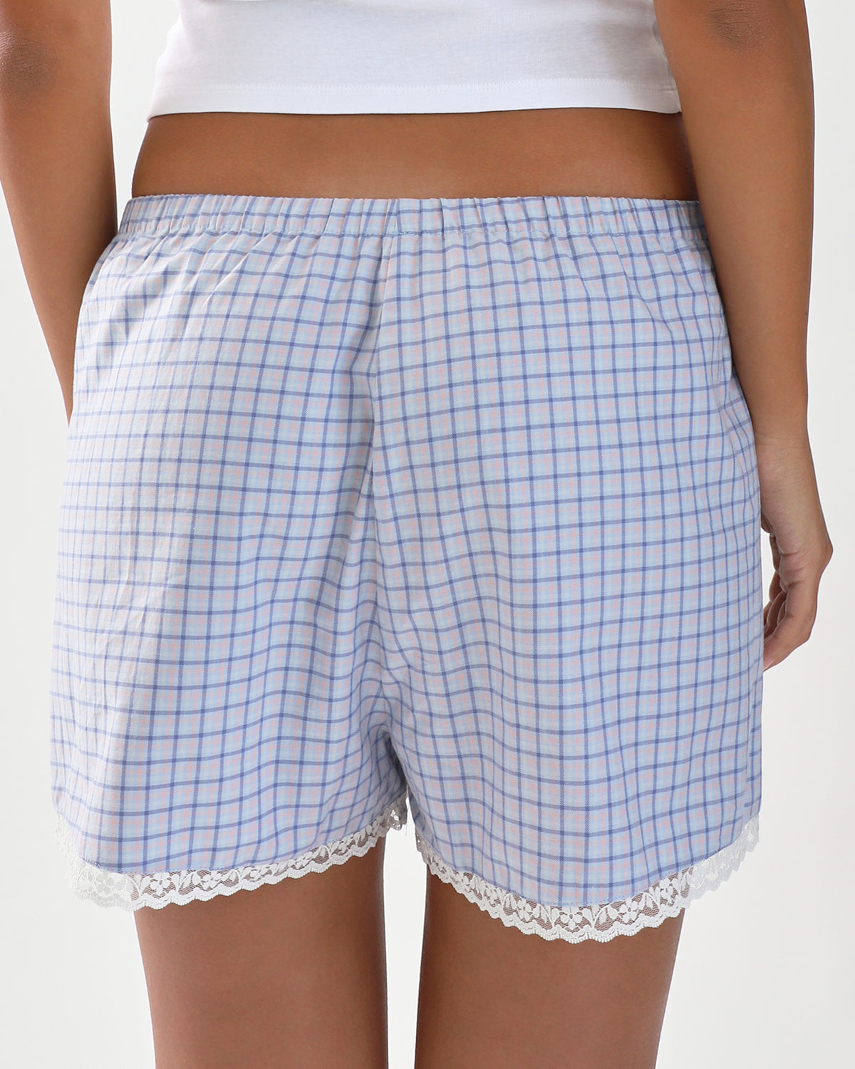 Blue checkered shorts with lace trim worn by a person on a white background