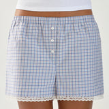 Blue checkered shorts with lace trim worn by a person on a white background