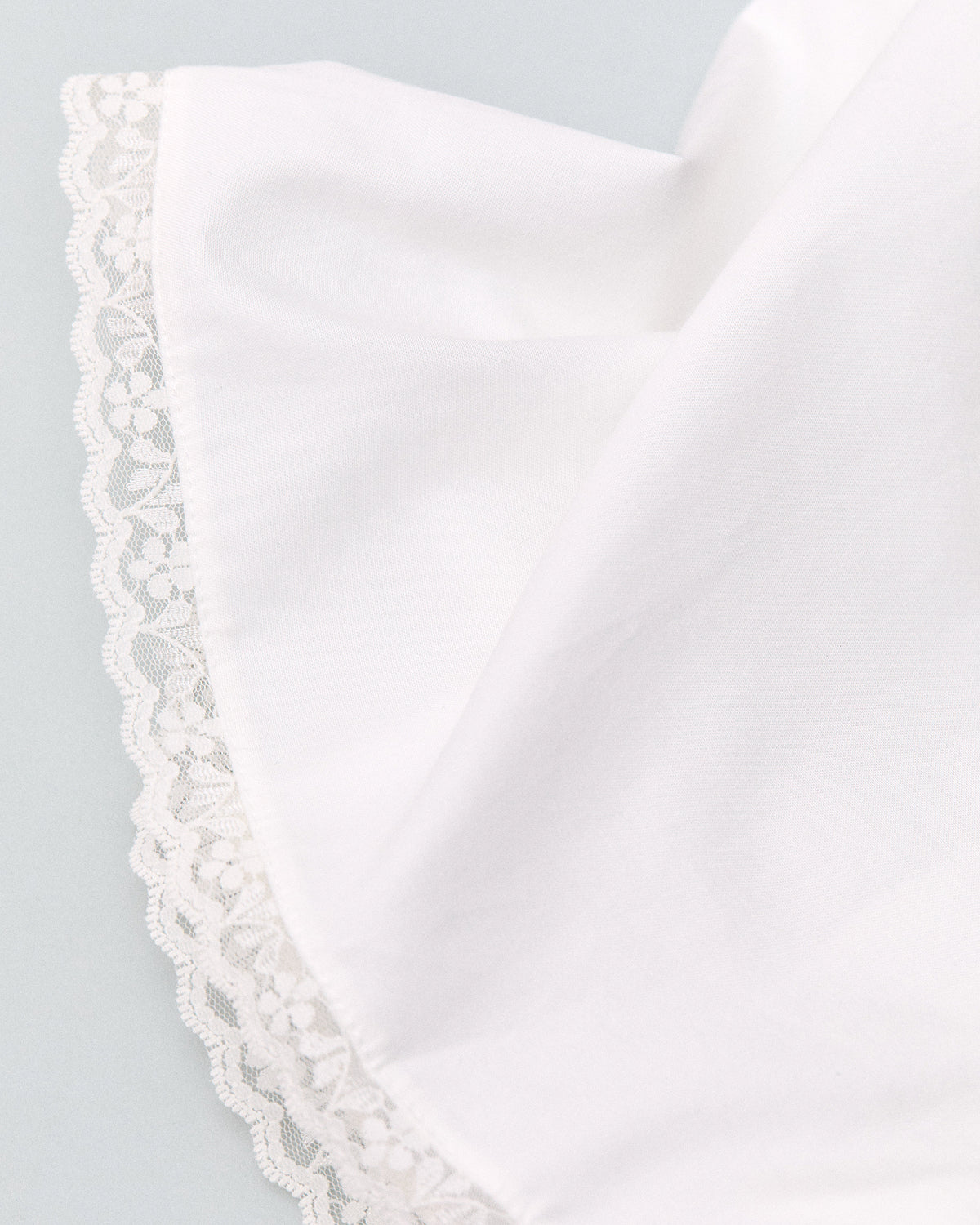 White boxers with lace trim on a light gray background