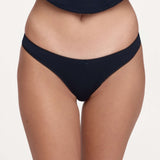 A close-up of a model wearing a pair of dark navy blue underwear against a plain light background.