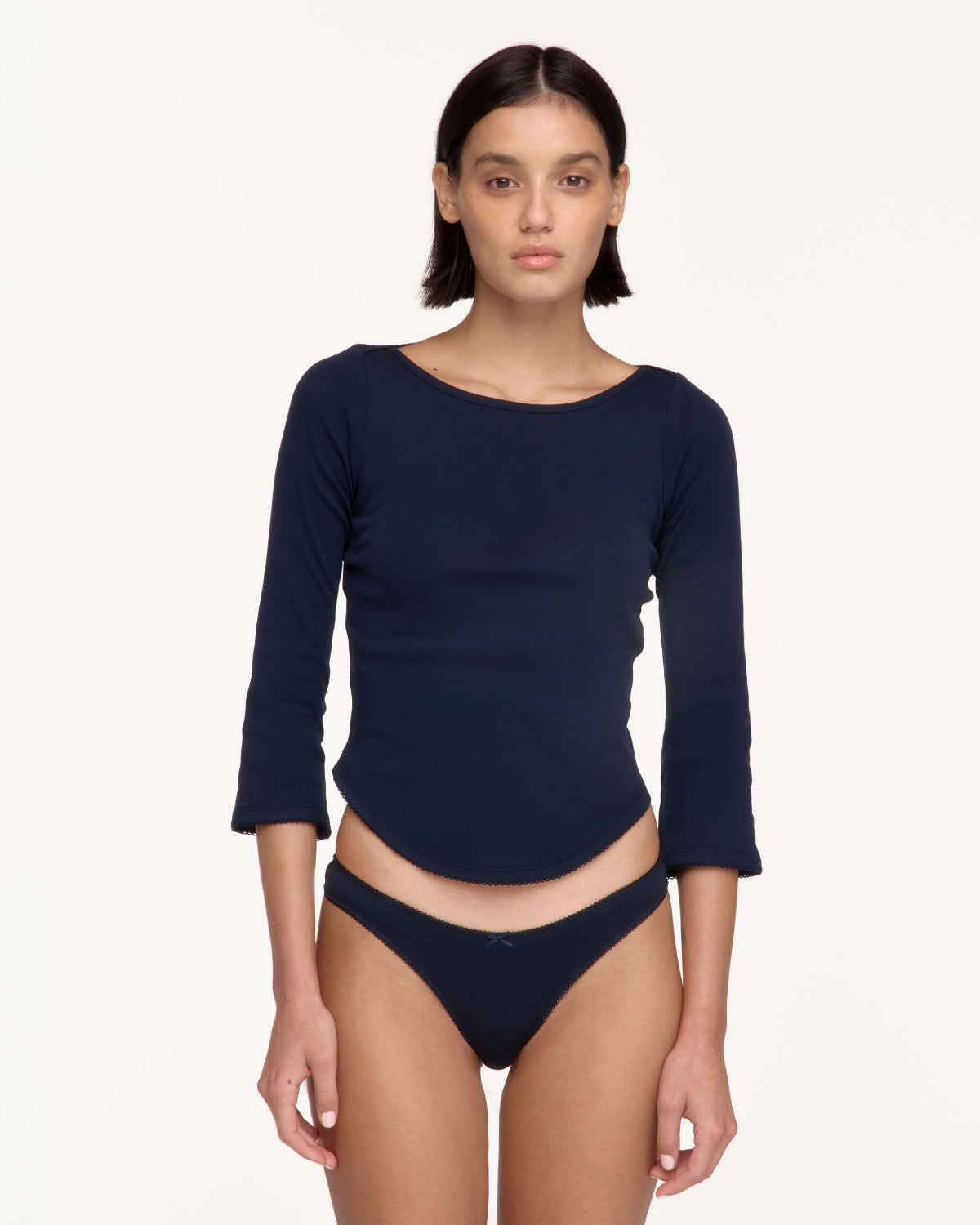 A model wearing a navy blue three-quarter sleeve swim top and matching underwear.