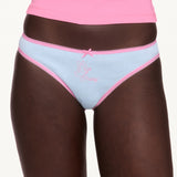 Woman wearing blue underwear with pink lace trim. 