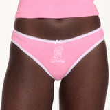Woman wearing pink underwear with white lace trim. 