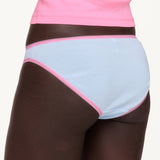 Woman wearing blue underwear with pink lace trim from the back. 
