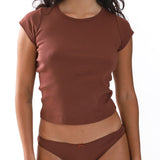 Woman wearing a brown cap-sleeve top and underwear set on a white background
