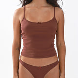 Woman wearing a brown tank top and underwear set on a white background