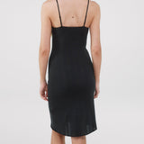 Black slip dress worn by a person on a white background