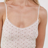White floral camisole worn by a person on a white background