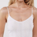 Close up of a camisole dress worn by a model on a plain background