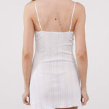 White ribbed dress with thin straps on a plain background