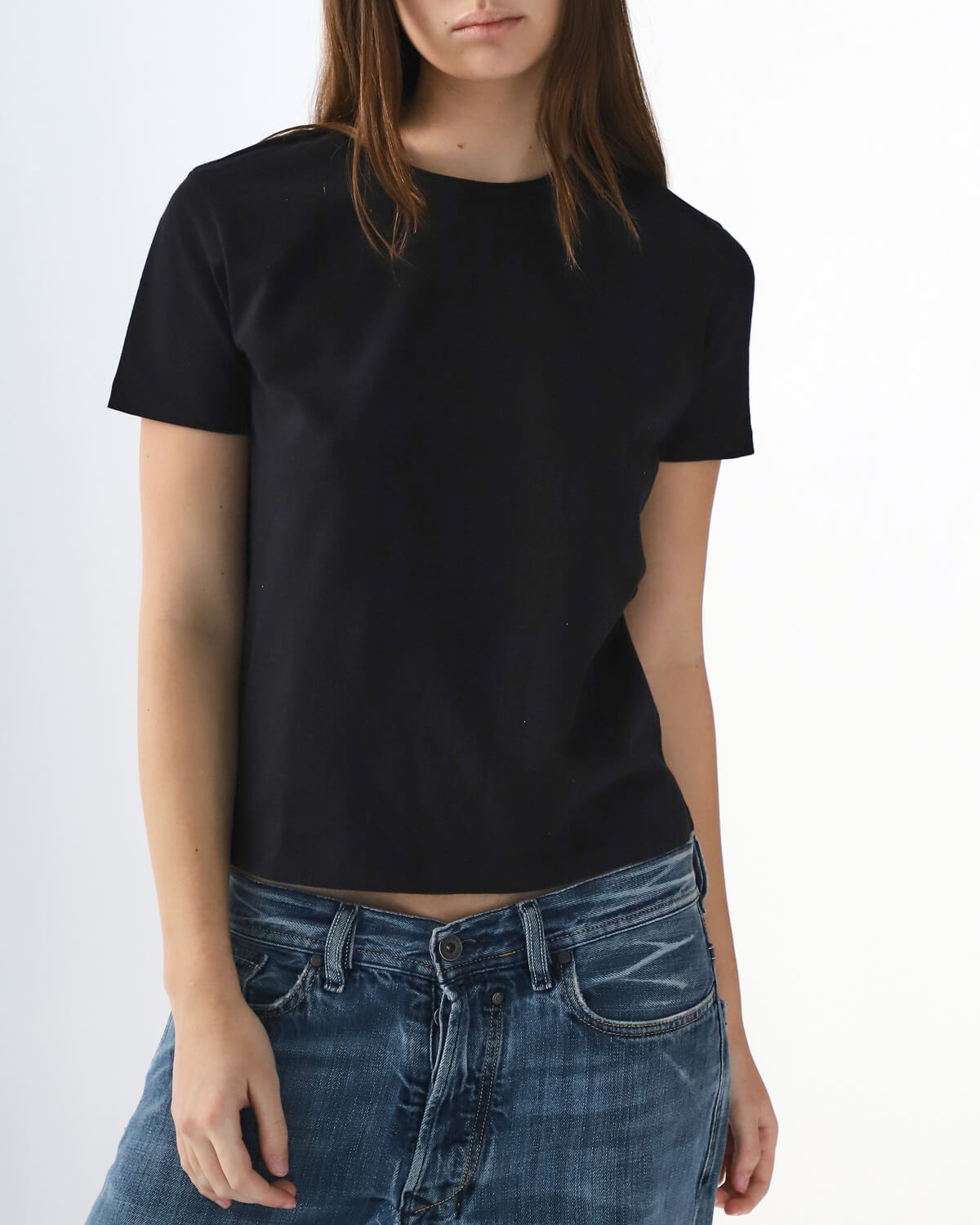 Person wearing a black t-shirt and blue jeans on a white background