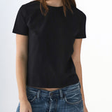Person wearing a black t-shirt and blue jeans on a white background