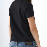 Person wearing a black t-shirt and blue jeans on a white background