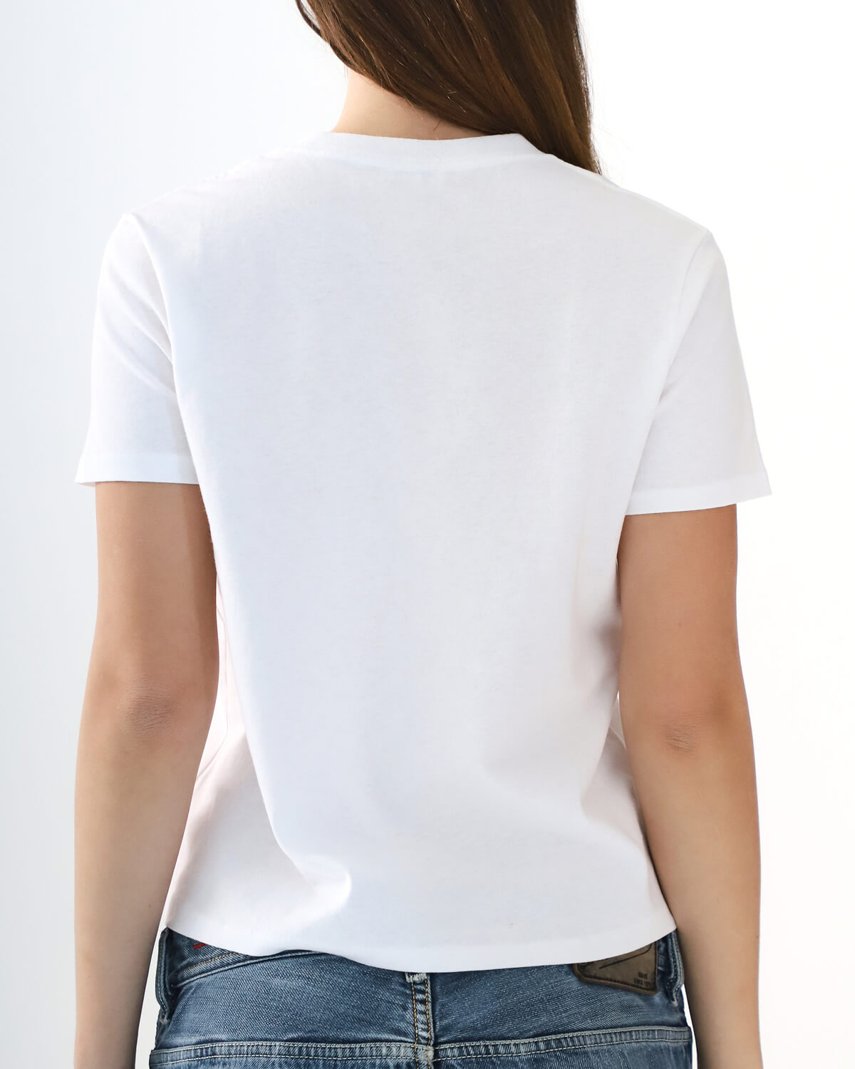 Person wearing a plain white t-shirt on a white background