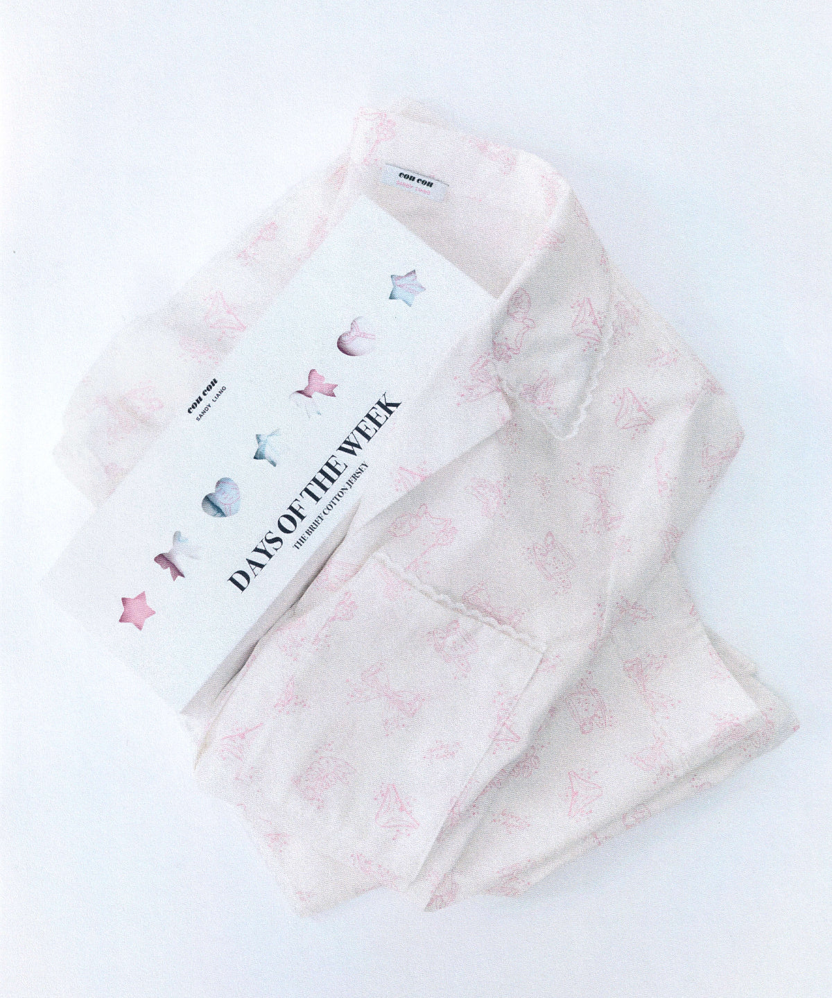 Folded white pajamas with pink print. 