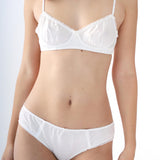 Person wearing a white bra and panties set on a plain background