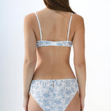 Woman wearing a blue floral underwear set on a white background