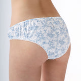 White underwear with blue floral pattern worn by a person on a plain background