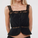 Black lace-trimmed top worn by a model on a white background