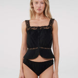 Woman wearing a black lace top and underwear set on a white background