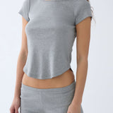 Person wearing a gray t-shirt and shorts set on a light gray background