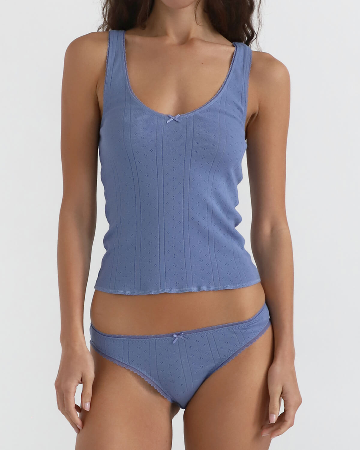 Woman wearing a blue tank top and brief on a white background