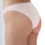 Light pink underwear worn by a person on a light gray background