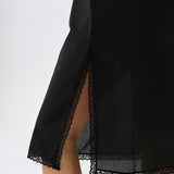 Black lace-trimmed dress on a white background