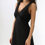 Black slip dress with lace details on a white background