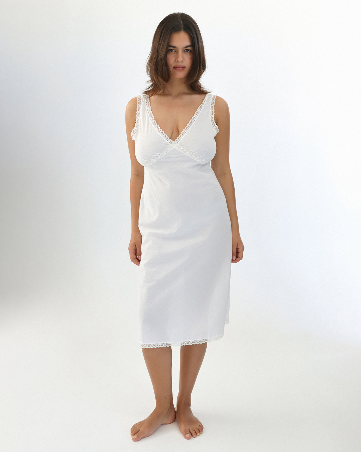Woman wearing a white dress on a plain background