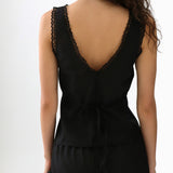 Black sleeveless top with lace detailing on a white background