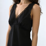 Black sleeveless top with lace details on a plain background