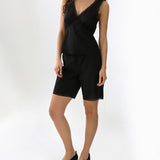 Woman wearing a black sleeveless top and shorts set on a white background