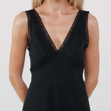 Black sleeveless dress with lace detailing on a plain background