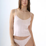 Woman wearing a light pink lingerie set on a white background
