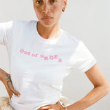Person wearing a white t-shirt with 'Out of Order' text in pink.